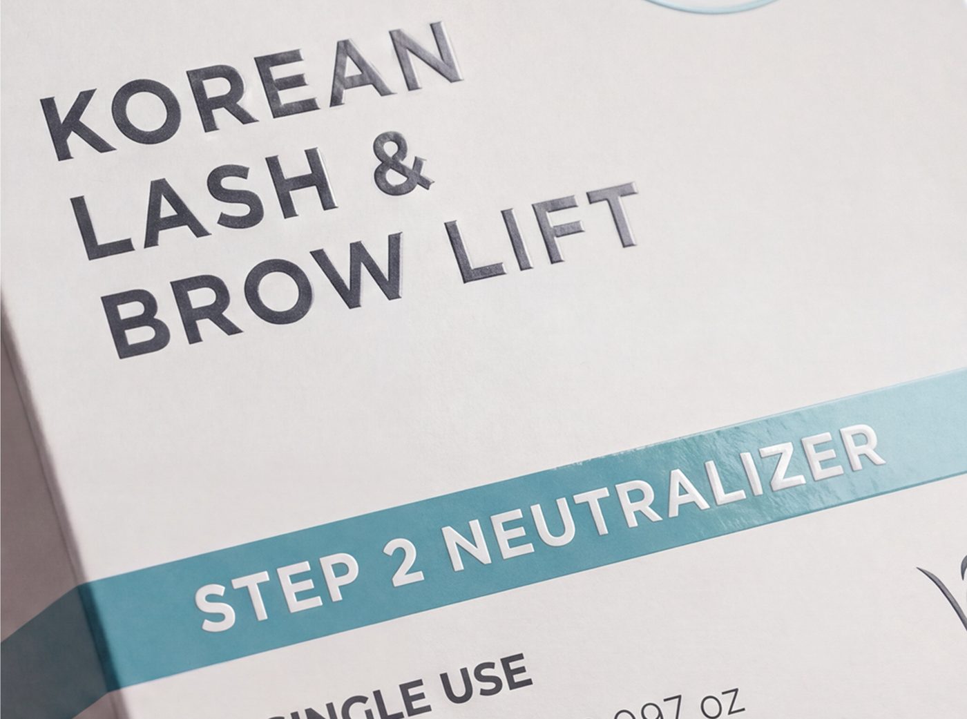 Close-up of the Step 2 Neutralizer teal band with white embossed lettering on a HARA Korean Lash and Brow Lift box